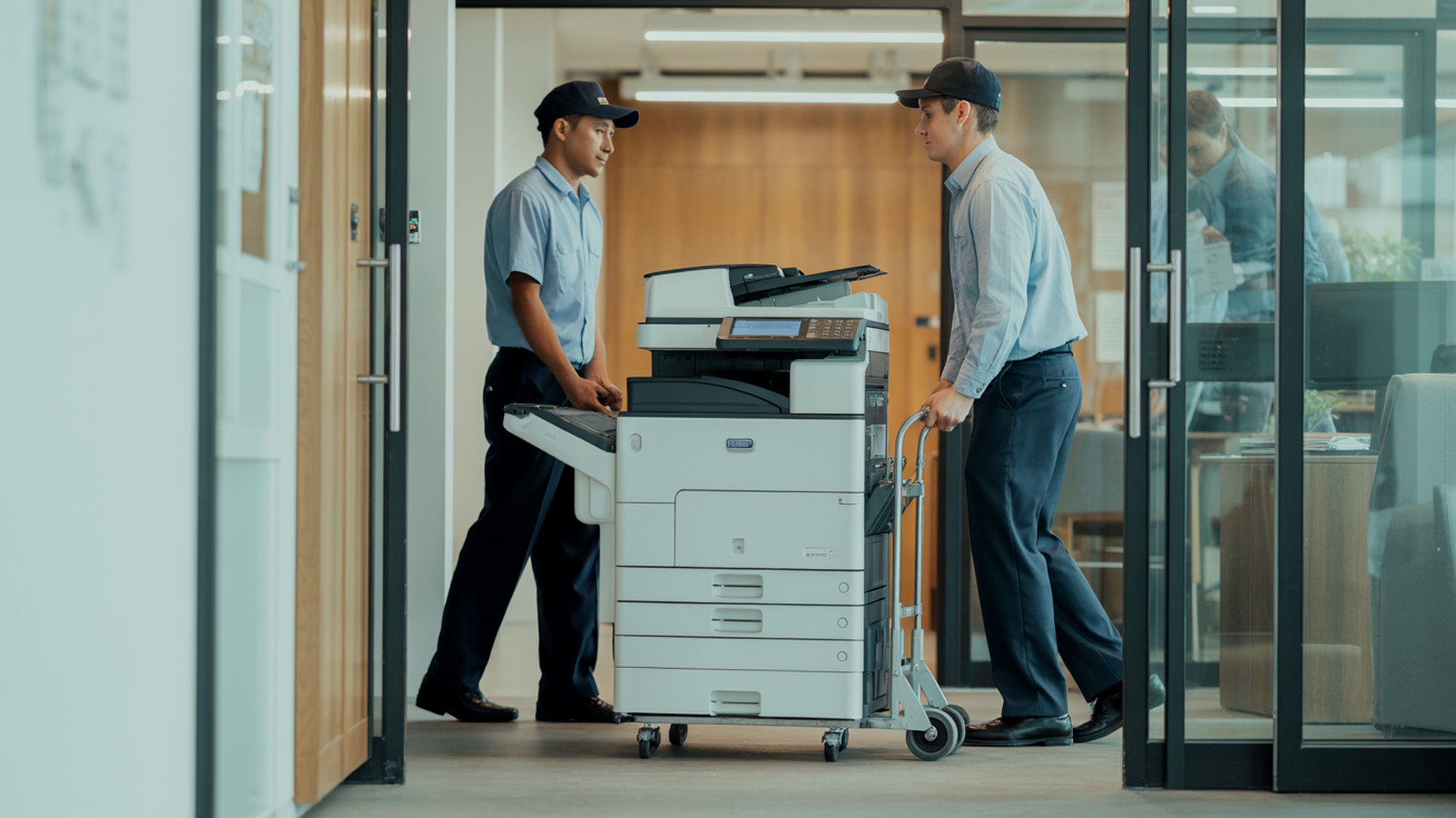 Copier delivery team wheeling a commercial printer into a Phoenix office for short-term rental